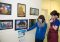 Image shown: Cloudlands participant Kayleigh Fox points to her artwork with artist Emma Fisher
